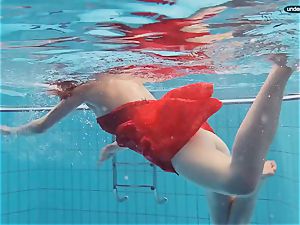 crimson dressed teen swimming with her eyes opened